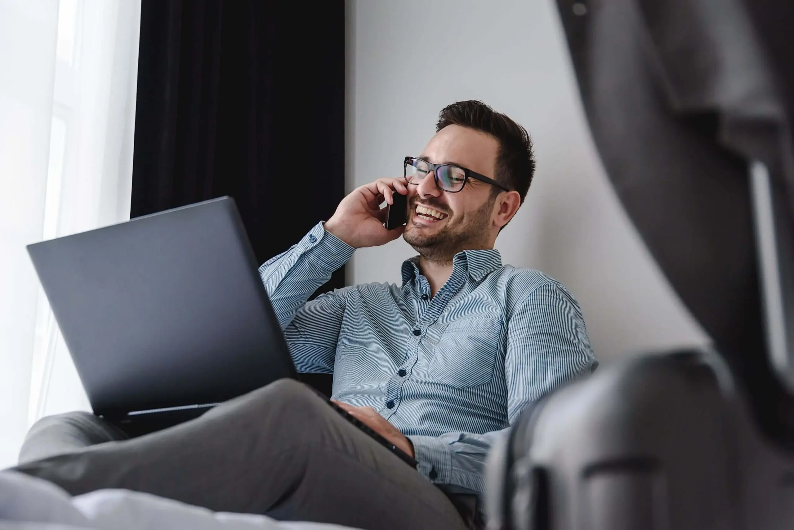 Geschaftsreisender Mit Laptop Und Handy In Unterkunft Scaled