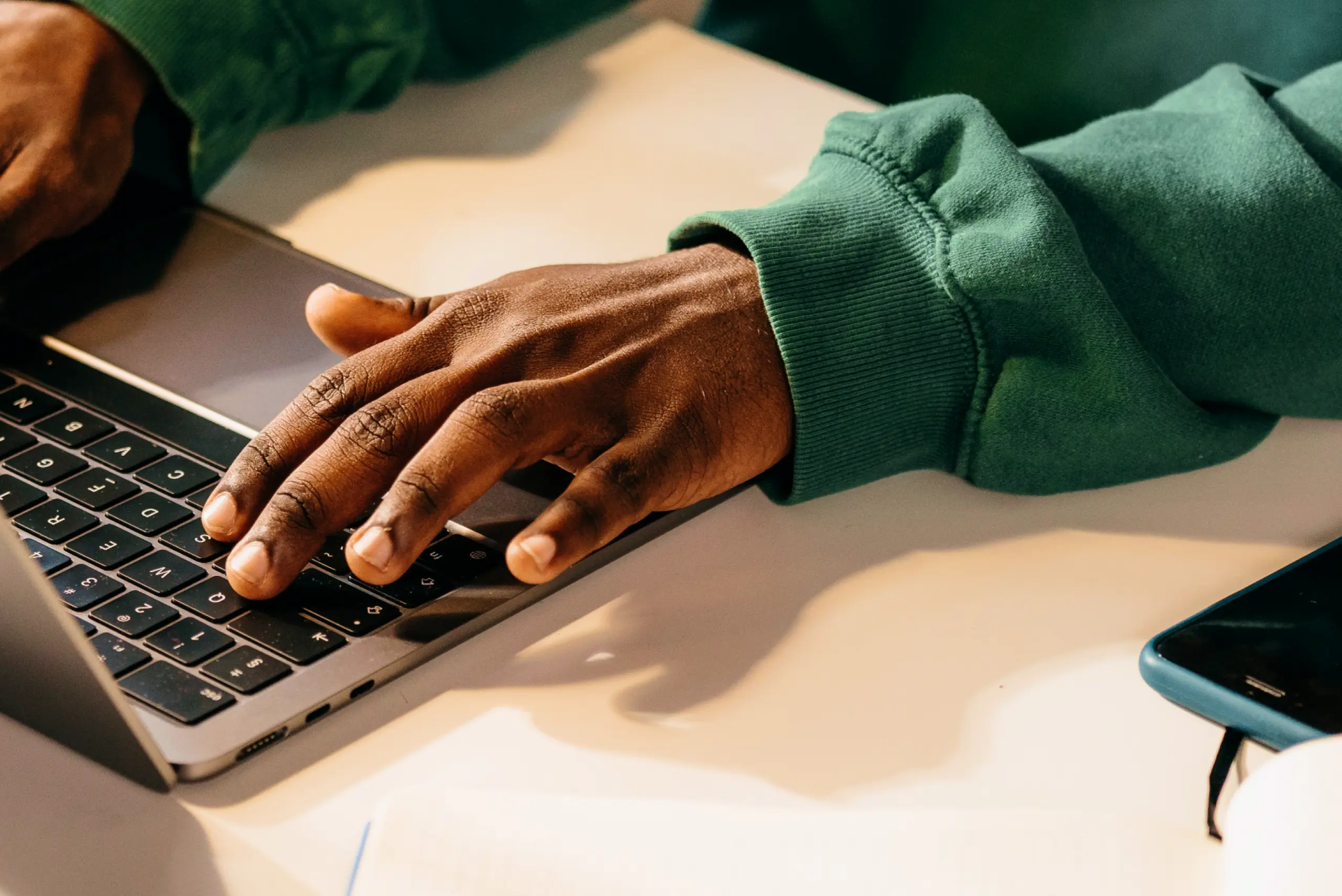 hands typing at a laptop keyboard