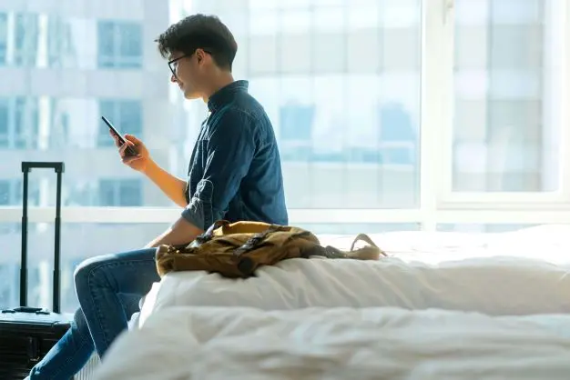Person Auf Hotelbett Mit Handy 1