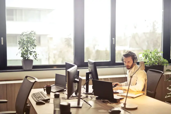 Mand At The Office With Haeadphones 720x480 1