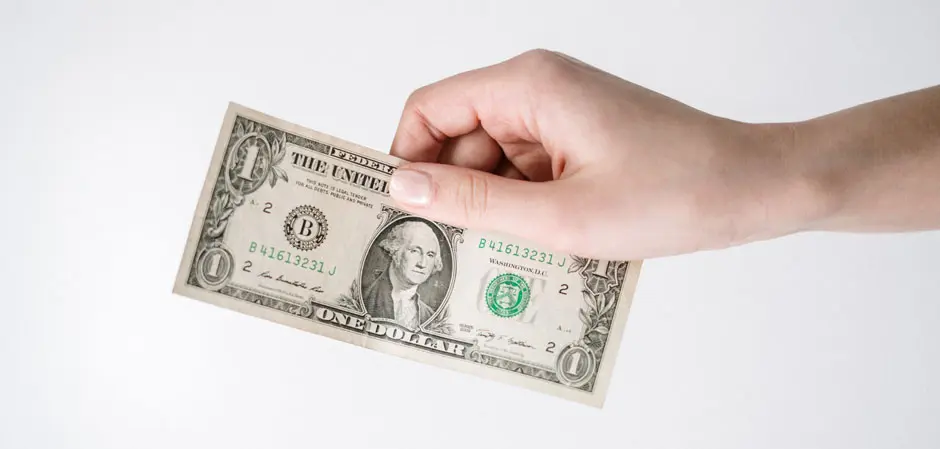 Hand Holding One Dollar 940x449 1