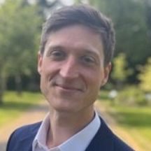 A man smiling while looking at the camera