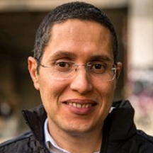 A man with glasses smiling at the camera.