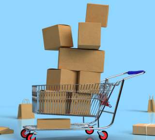 A shopping cart loaded with stacked cardboard boxes against a blue background, with additional bags and boxes nearby.