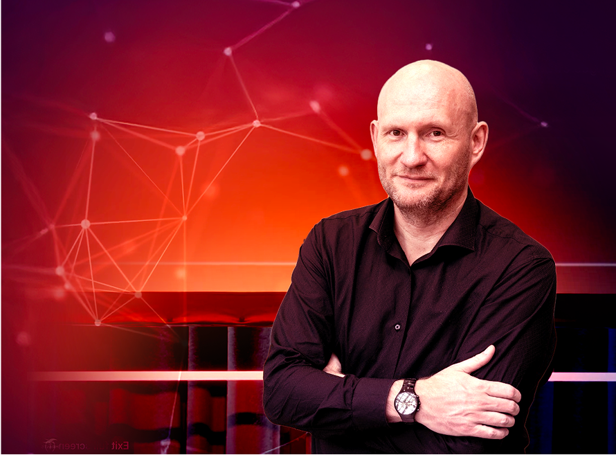 A man standing in front of a red screen.