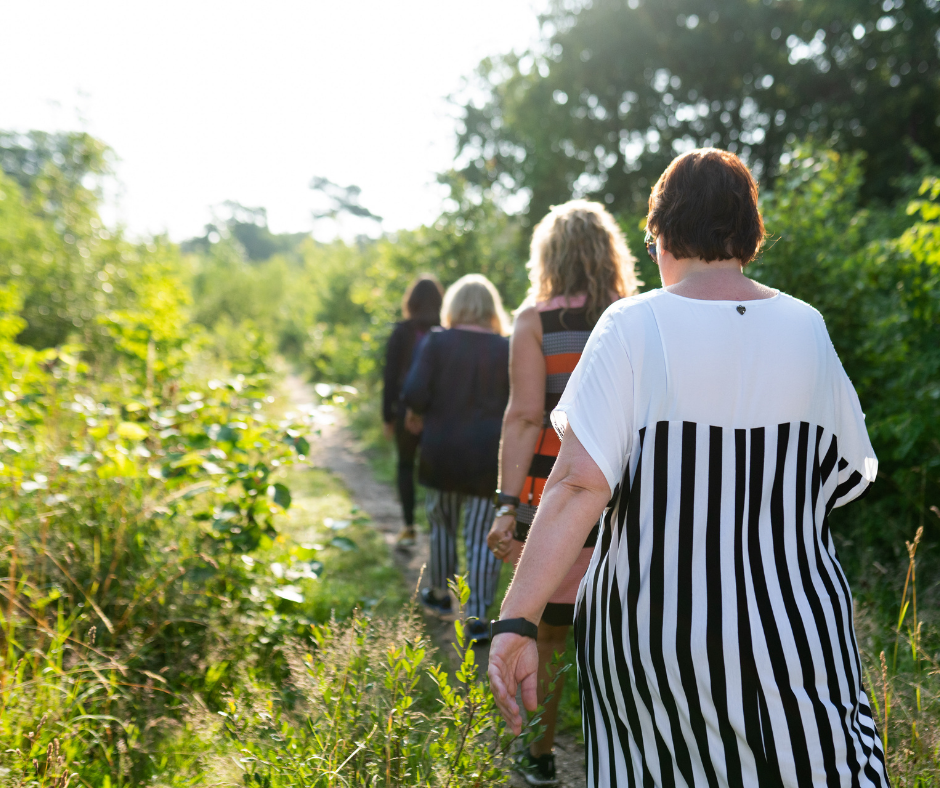 Een groep van vrouwen lopend op een pad in de natuur.