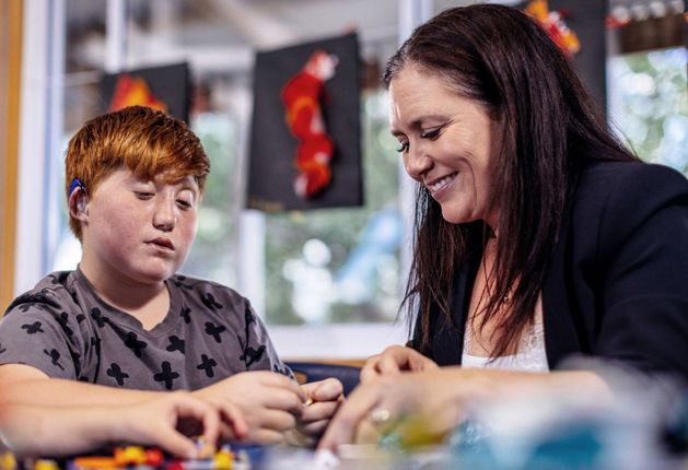 Child and adult playing with Lego together