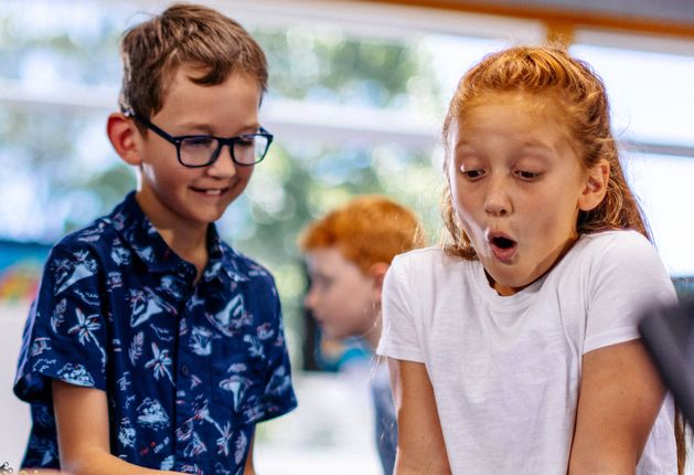 Two children looking excited at a brick club