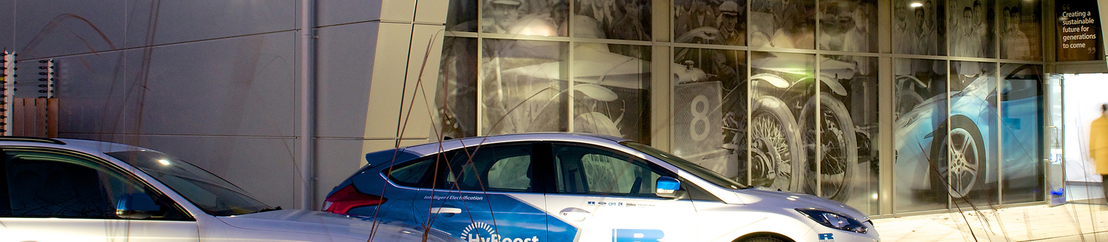 Two Ricardo branded cars infront of an innovation centre.