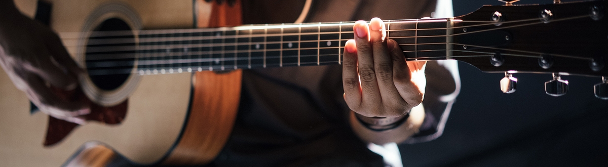 Cl;ose up of man playing guitar
