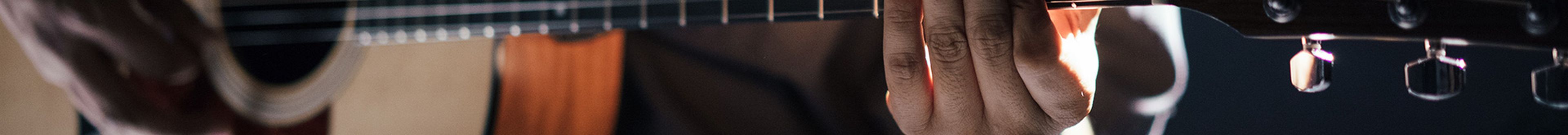 Cl;ose up of man playing guitar