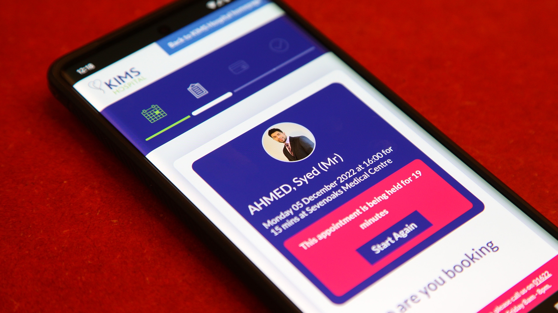 The KIMS Hospital Online Booking Portal on a mobile phone.