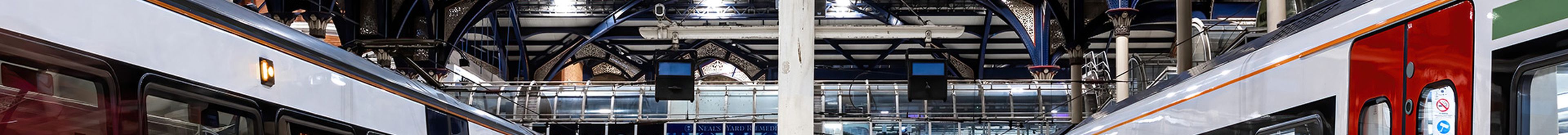 Two trains from a low viewing angle in a rail station.