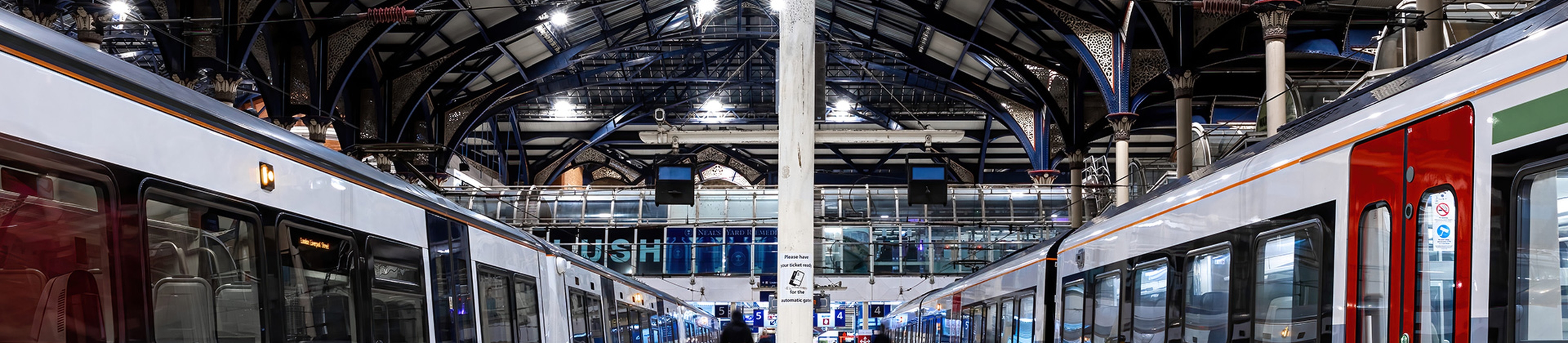 Two trains from a low viewing angle in a rail station.
