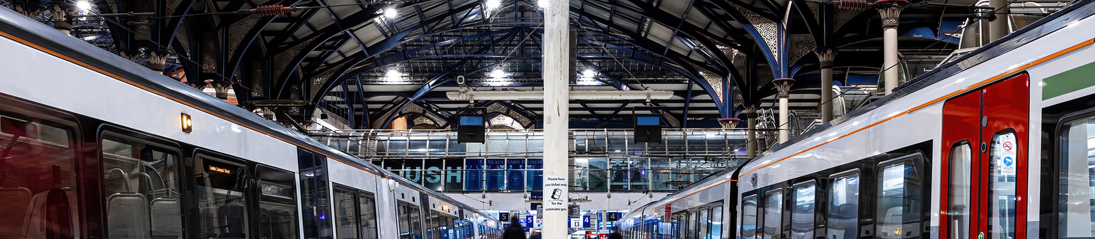 Two trains from a low viewing angle in a rail station.