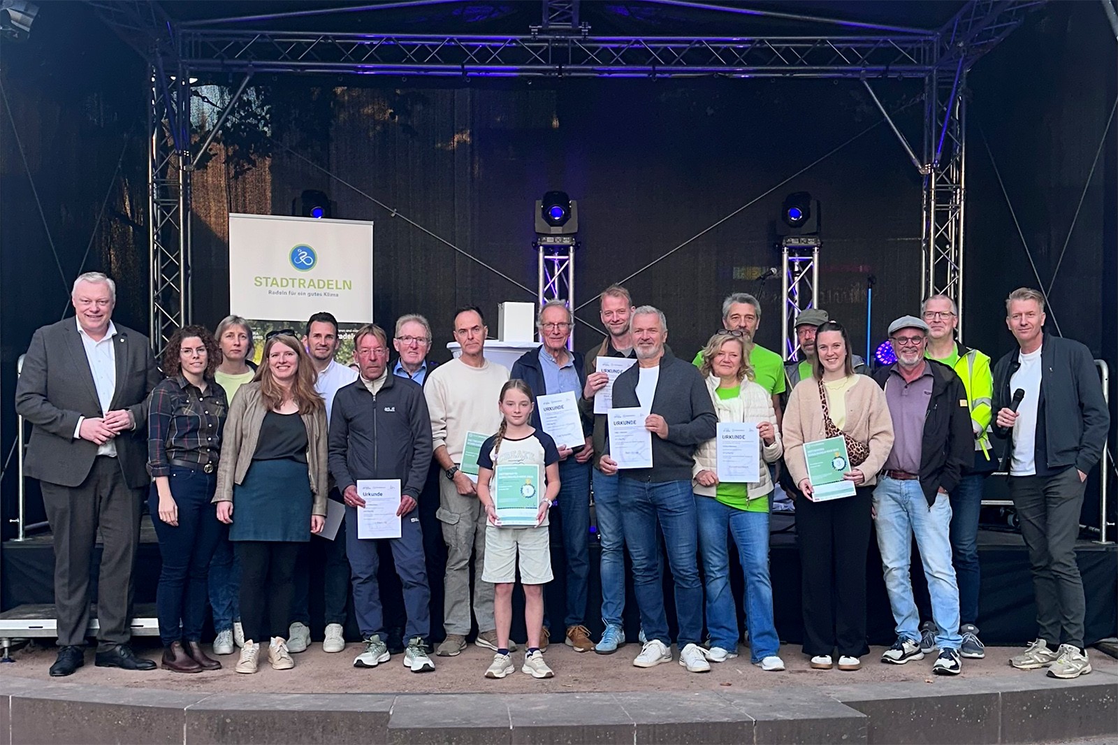 Die ausgezeichneten Teilnehmerinnen und Teilnehmer des Stadtradeln 2026 gemeinsam mit Bürgermeister Daniel Hartmann (links) und Moderator Markus Finger (rechts) bei der Preisverleihung auf dem Höxteraner Marktplatz.