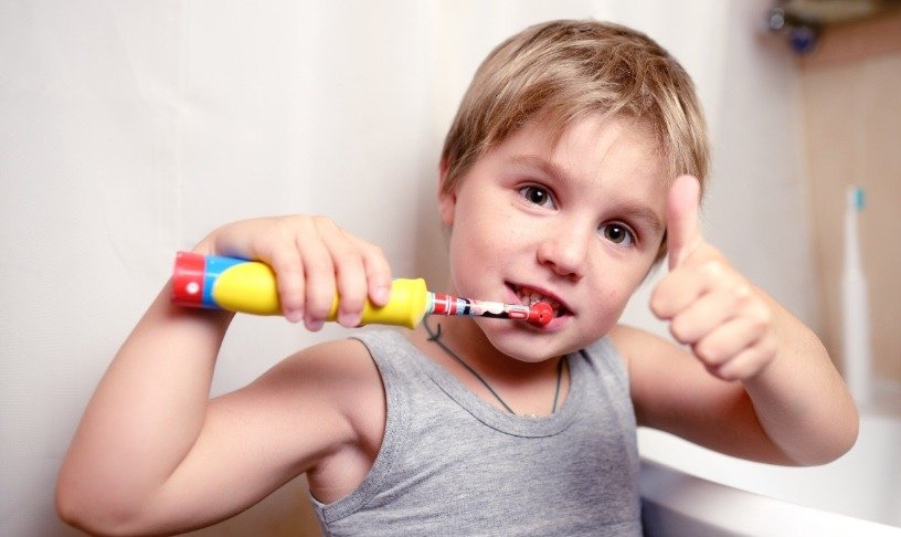 Bambino con spazzolino elettrico