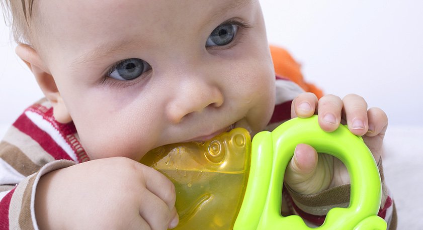 Neonato con giochino da dentizione
