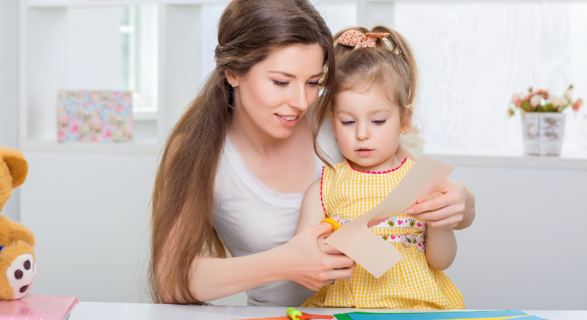 Mamma e figlia che ritagliano un foglio