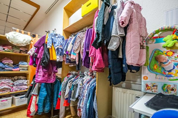 In Schränken und Regalen hängt Kinderkleidung