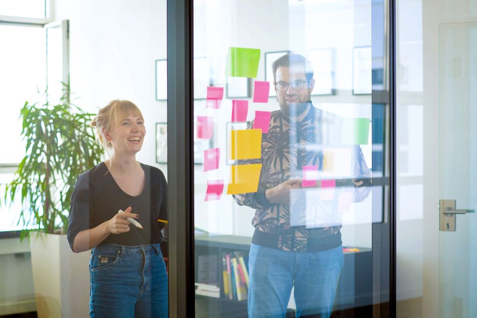 Woman and man working together with post its