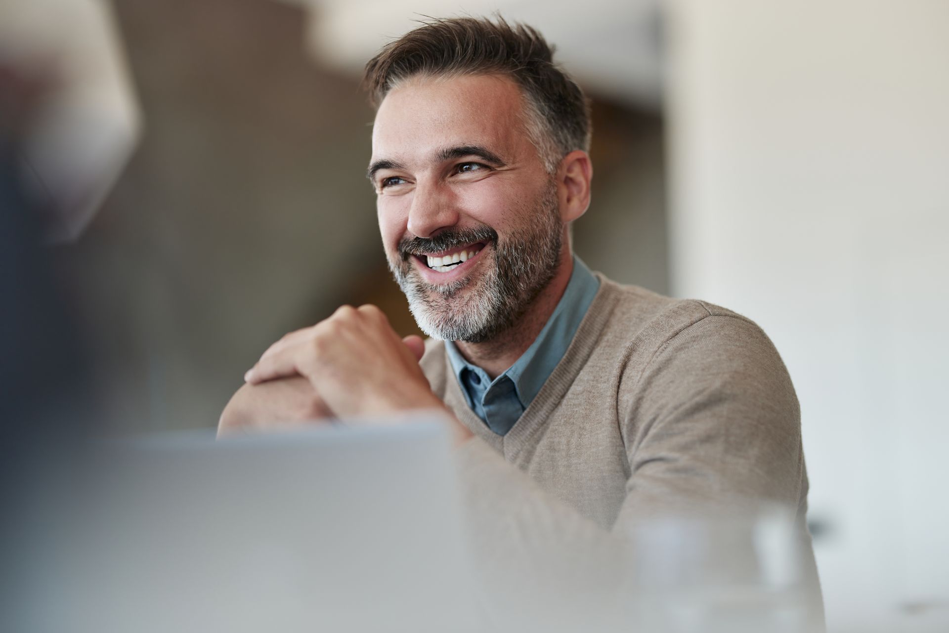 Glücklicher Geschäftsmann im mittleren Erwachsenenalter, der im Büro genießt