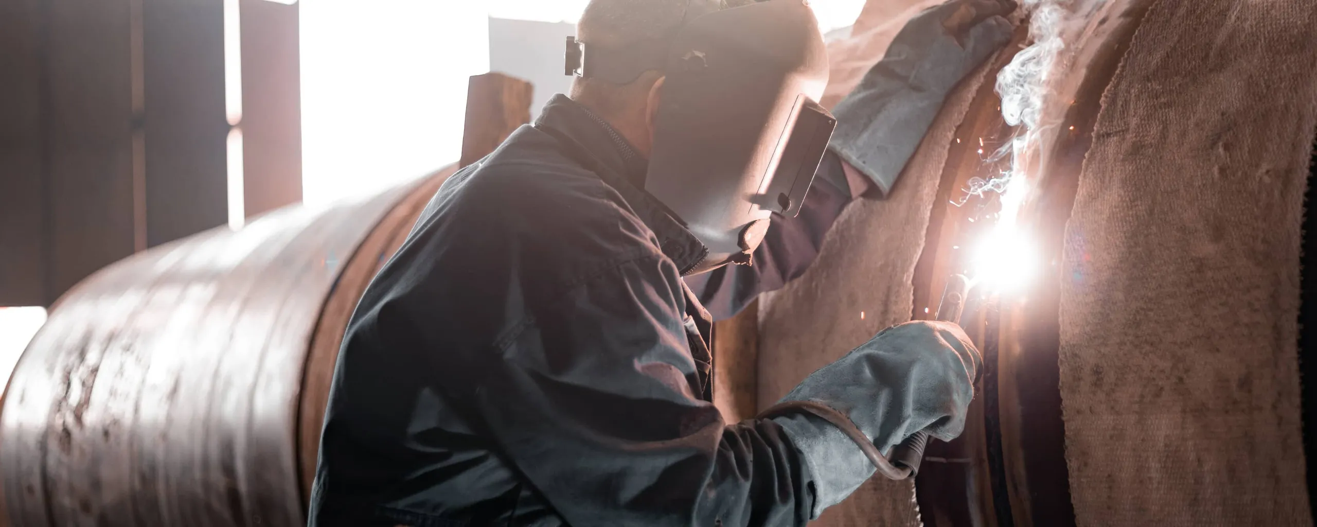 En mand, der svejser i industrien.