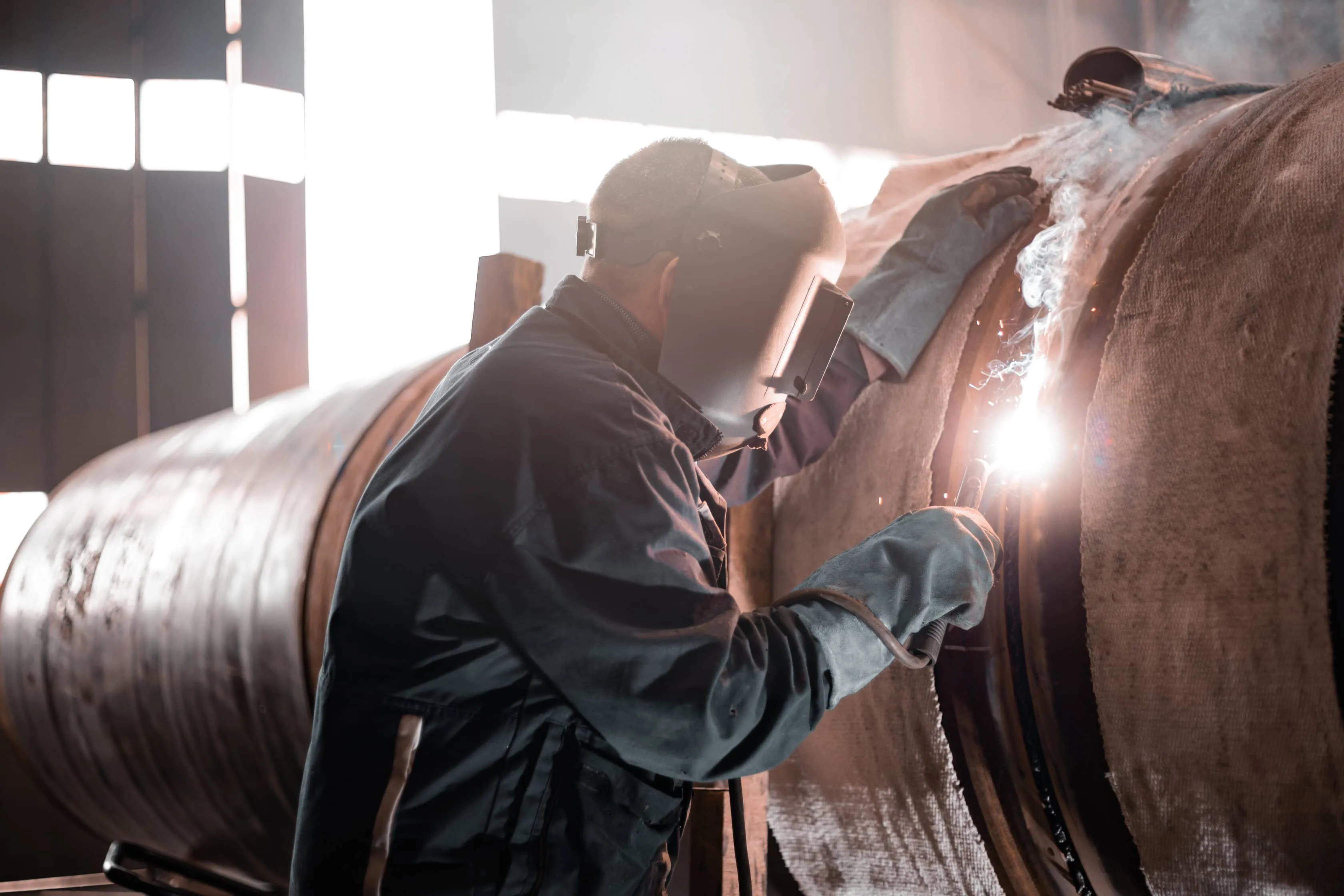 En mand, der svejser i industrien.