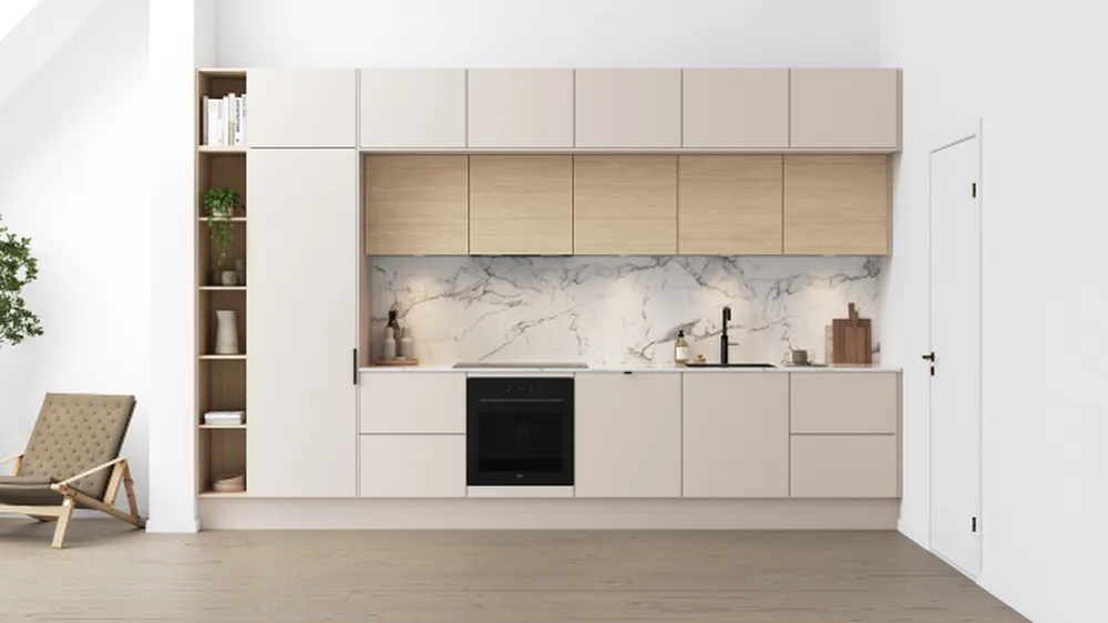 Modern kitchen with beige cabinets, marble backsplash, black oven, and a wooden shelf. Minimalist decor includes a small potted plant and chair.