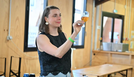 Zythologue observant la couleur d'une bière dans un verre à dégustation pendant un atelier
