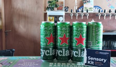 Canettes de Heineken posée sur un bar avec à coté un kit pour déceler les défauts de la bière