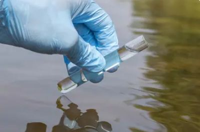 Vial of water being taken for testing