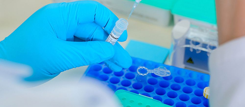 Close up of scientist extracting fluid from a vial