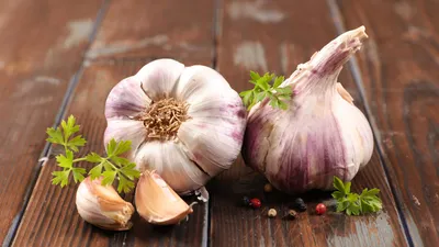photograph of garlic bulbs on wooden surface