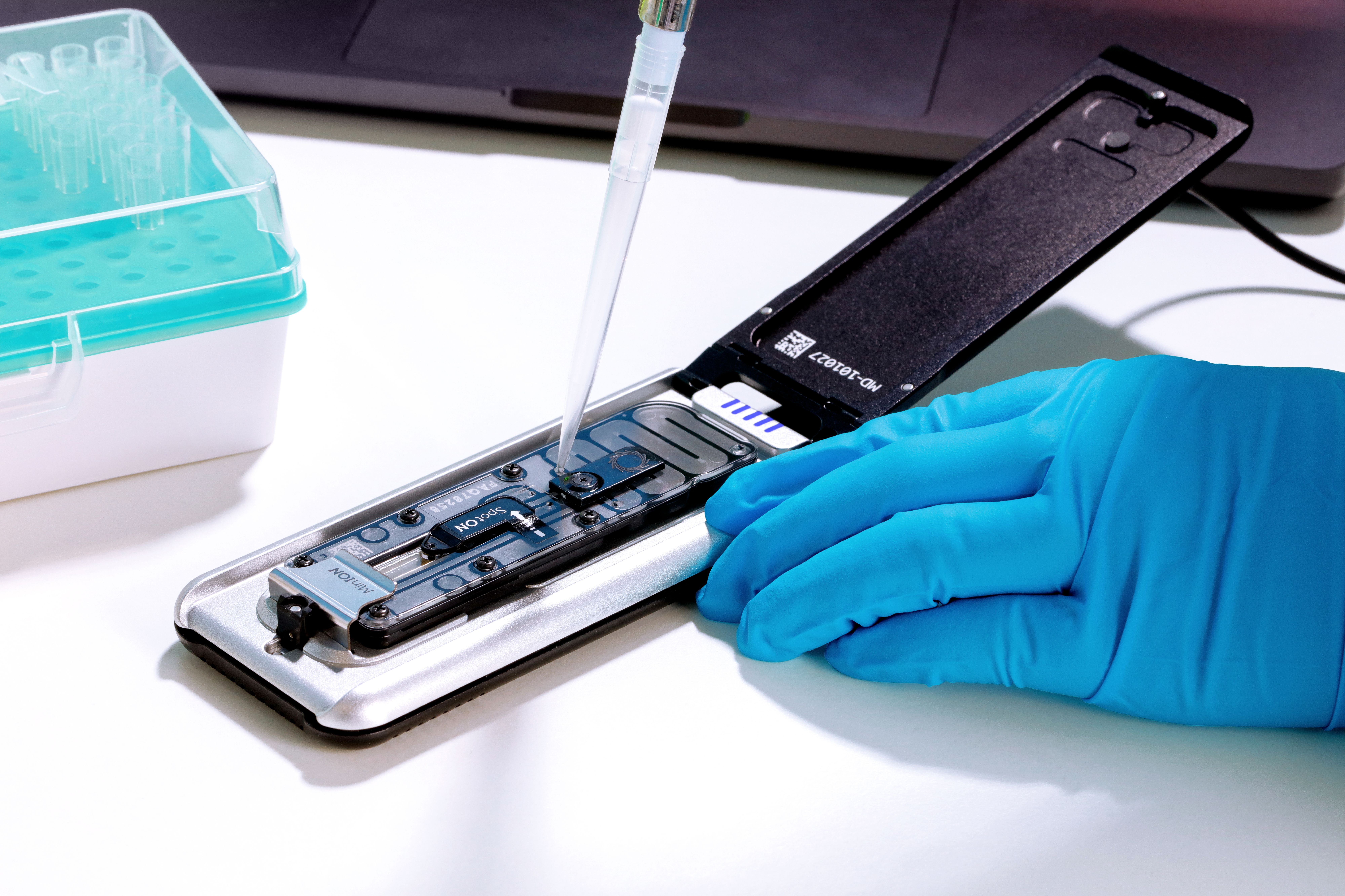 Mk1D attached to a laptop on a lab workbench - open, pipetting copy