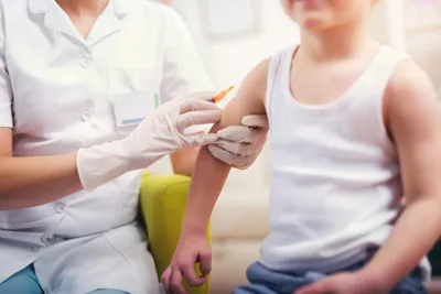 boy being vaccinated in arm by nurse