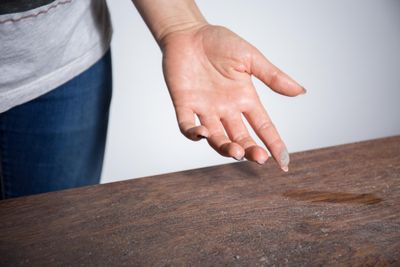 photograph of dust on person's finger collected from table surface