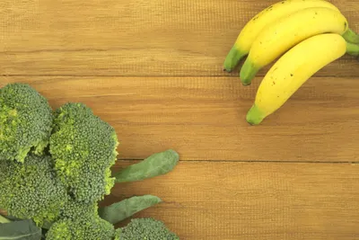 bananas and broccoli on wooden surface
