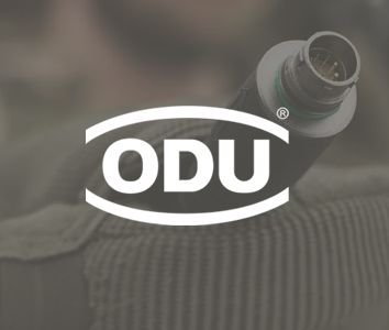 Close-up of a cable with a round connector held against a blurred background, overlaid with the ODU logo in white.