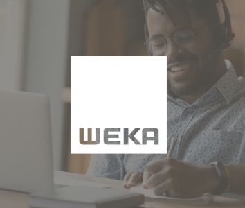 Person smiling, wearing headphones and writing in a notebook in front of a laptop. Centered over the image is the WEKA logo.