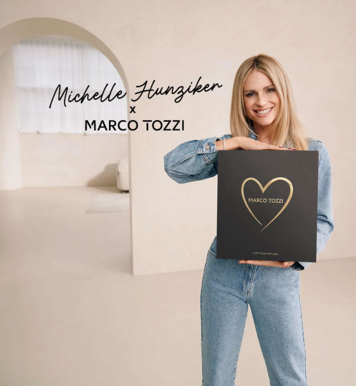Blonde Frau lächelt in die Kamera und hält dabei einen Schuhkarton von Marco Tozzi in den Händen