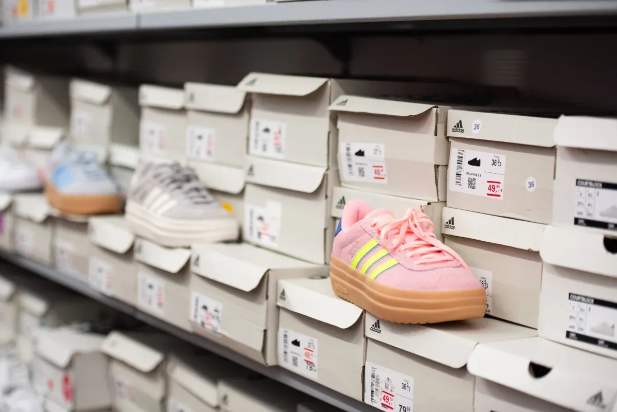 Regale voller Schuhkartons, in denen ein pink-gelber Turnschuh prominent ausgestellt ist.