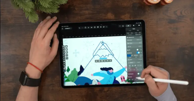Male hands drawing on an iPad positioned on a wooden table
