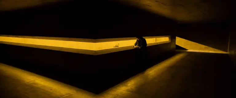 Man standing at a reception covered in yellow light