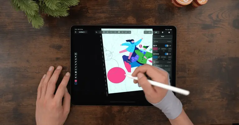 Male hands drawing on an iPad positioned on a wooden table