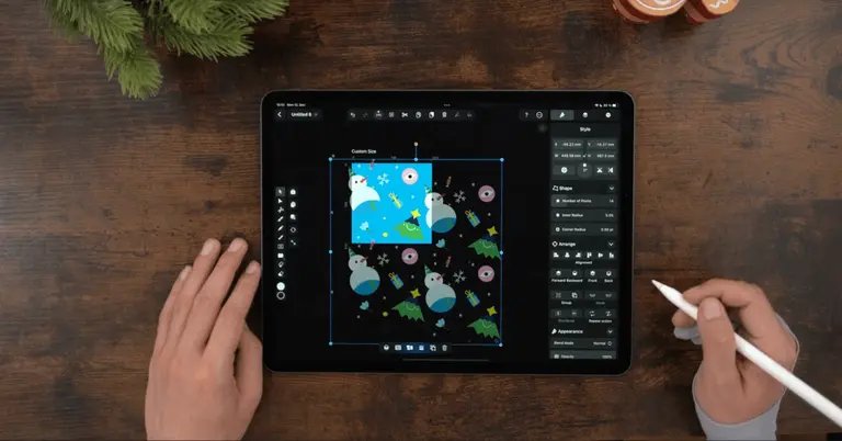Male hands drawing on an iPad positioned on a wooden table
