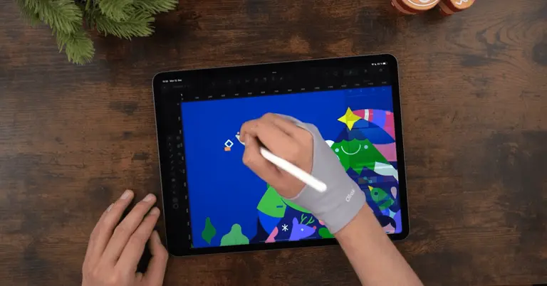 Male hands drawing on an iPad positioned on a wooden table