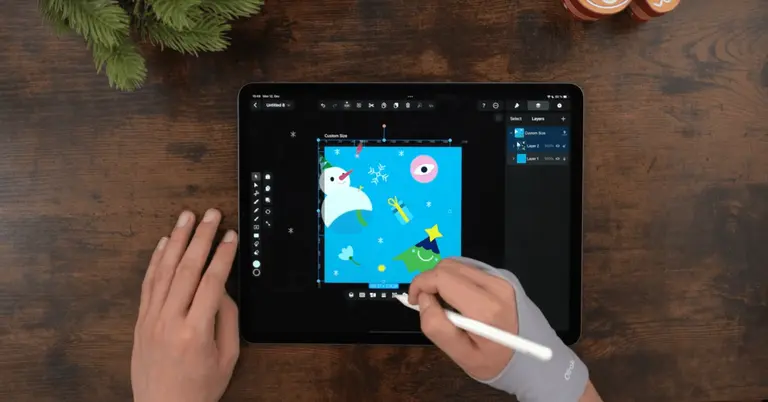 Male hands drawing on an iPad positioned on a wooden table