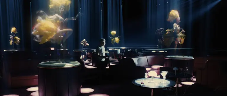 Man surrounded by female holograms