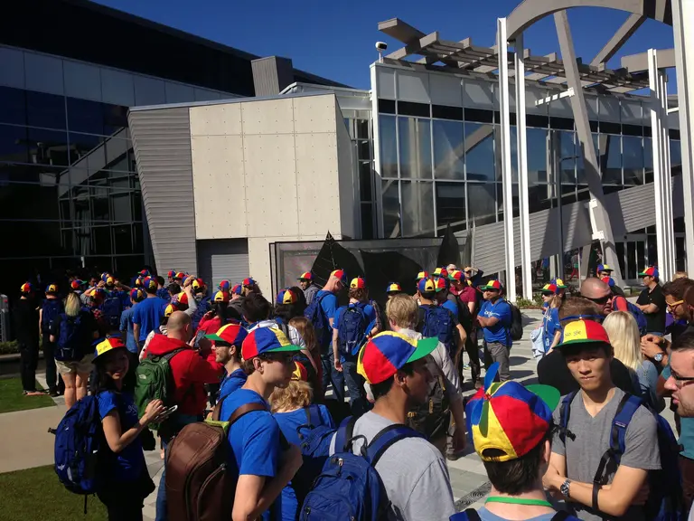 Group of people with Google caps in front of the Google headquarter